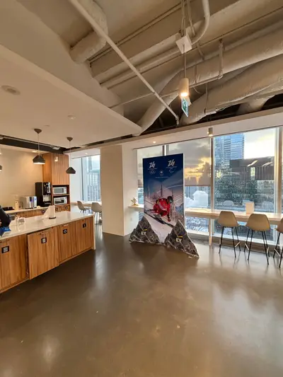 A compact Milano Cortina 2026 Team Canada retractable banner with a single mountain prop placed in a modern office kitchen area.