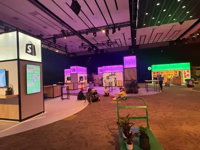 A wide-angle view of a large venue shows multiple Shopify product area booths including Sidekick, Retail, and Dot Dev.