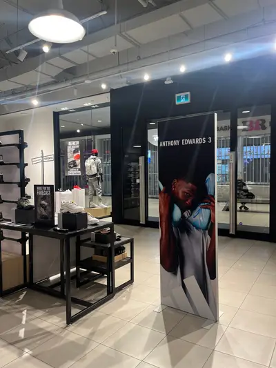 An Anthony Edwards 3 branded freestanding display banner positioned at the entrance of a Foot Locker Toronto retail store.