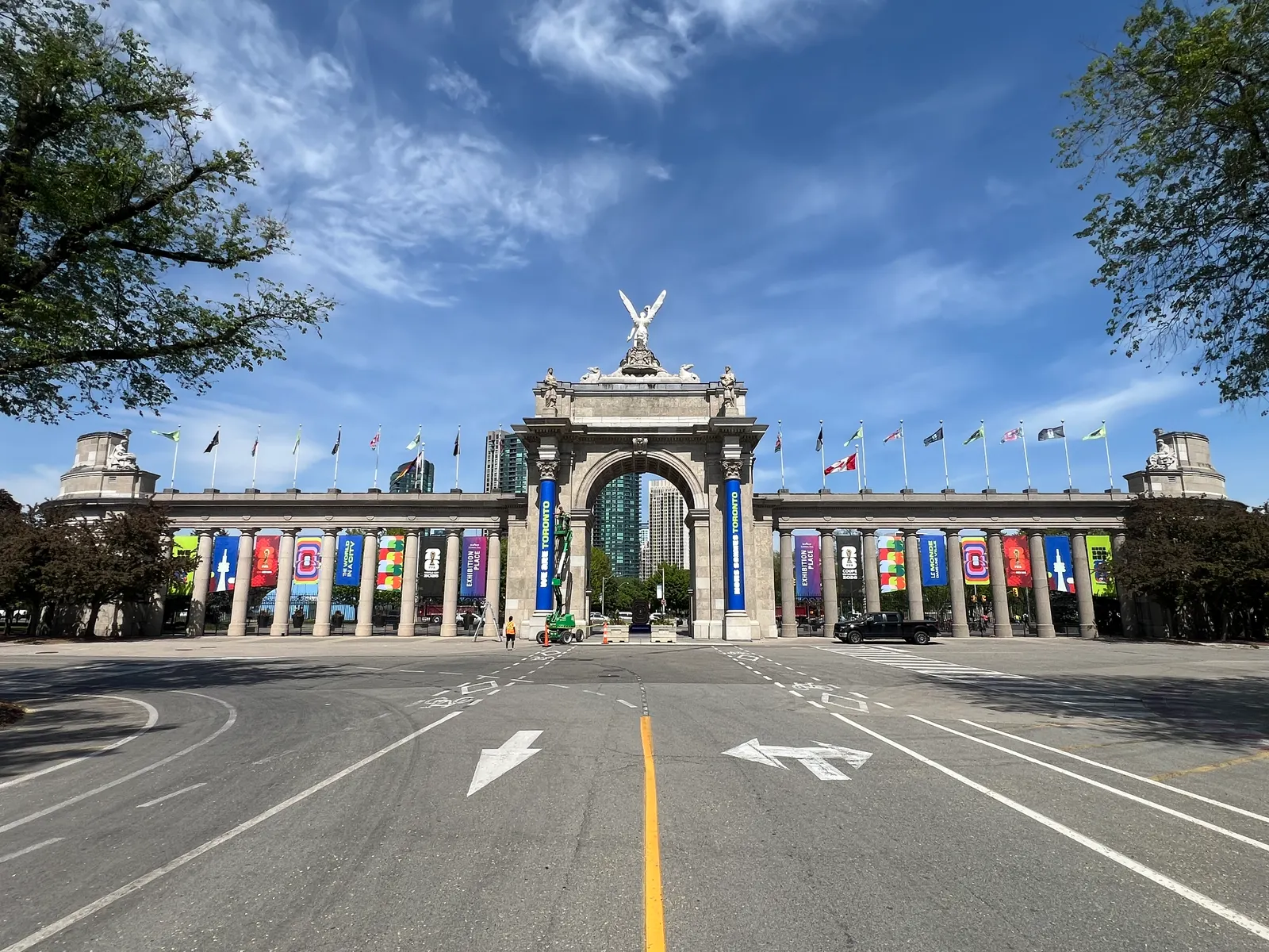The Princes' Gates arch at Exhibition Place is decorated with colorful banners under a blue sky.