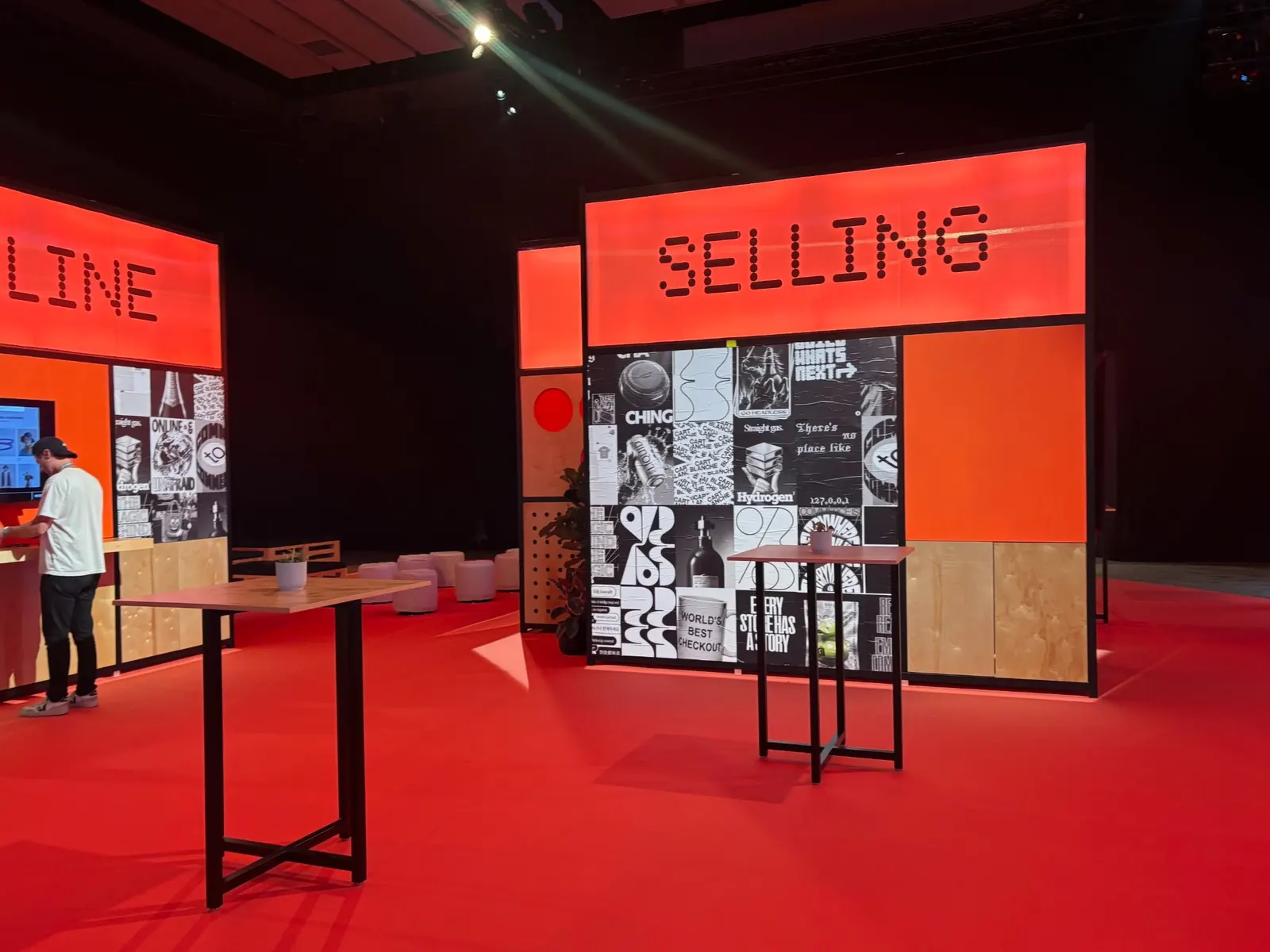 Shopify Selling and Online product booths display bold red illuminated signage and collage-style graphic walls in an event hall.